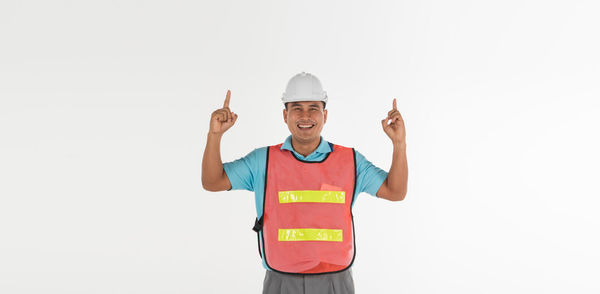 Portrait of smiling man standing against white background