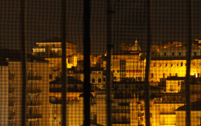 Reflection of buildings on glass window at night