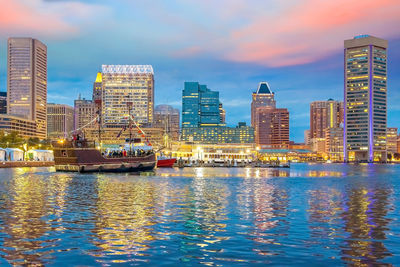 Illuminated buildings in city against sky