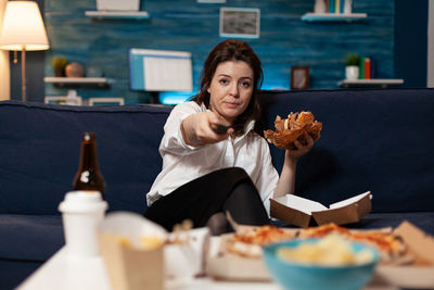 Young woman sitting on sofa at home