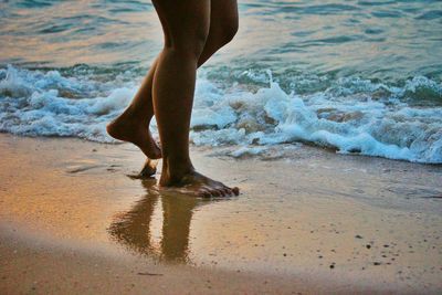 Low section of people standing on beach
