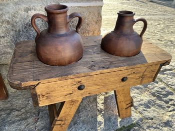 Close-up clay pots on top of wooden stand