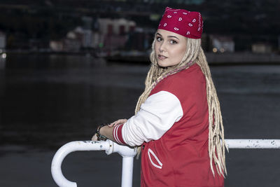Blonde woman in red with dreadlocks looking at camera