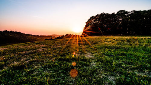 Scenic view of field against sky during sunset