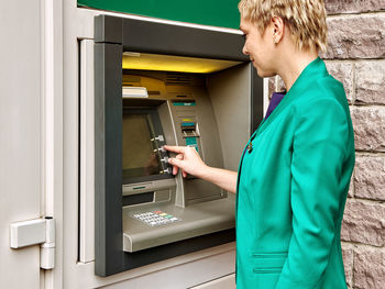 Close-up of businesswoman using atm machine