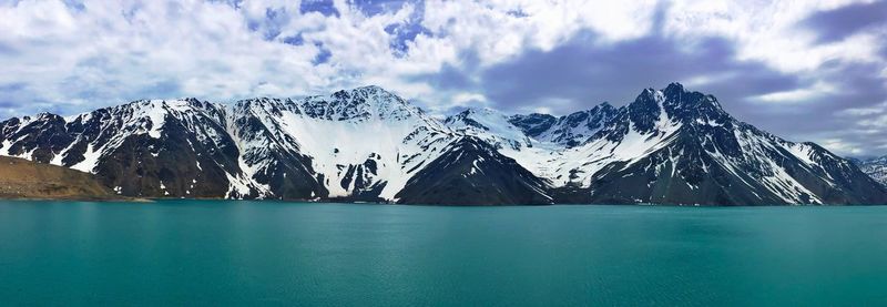 Panoramic shot of snowcapped mountain range against blue sky