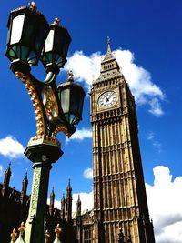 Low angle view of street light and big ben against sky