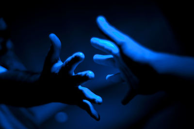 Cropped hands of people in illuminated room