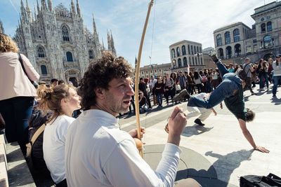 People on street against buildings in city