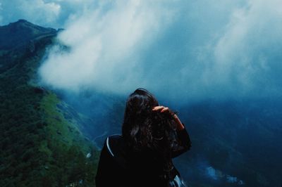 Rare view of a woman overlooking a cloud wall in devikulam, kerala, india