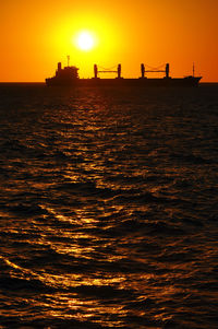 Scenic view of sea against orange sky