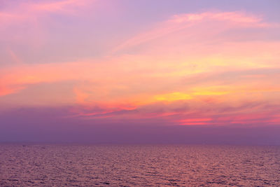 Scenic view of sea against dramatic sky during sunset