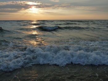 Waves rushing towards shore during sunset