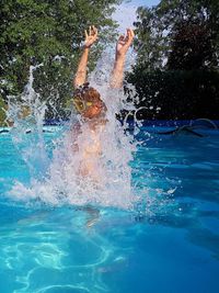 Boy jumping in swimming pool