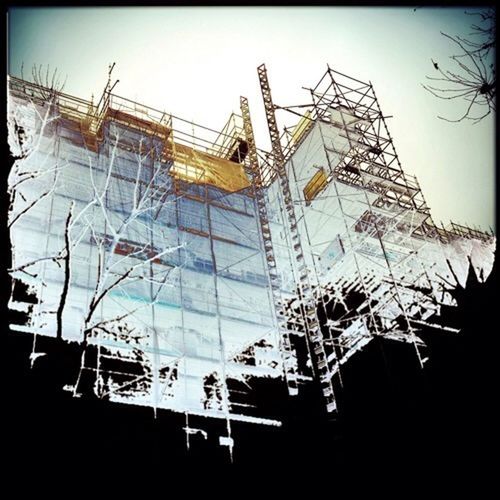 architecture, built structure, building exterior, low angle view, clear sky, auto post production filter, building, transfer print, construction site, day, sky, glass - material, construction, no people, outdoors, development, city, scaffolding, window, crane - construction machinery