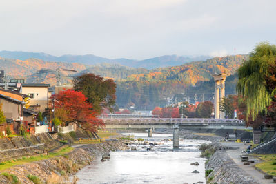 Scenic view of river by buildings against sky