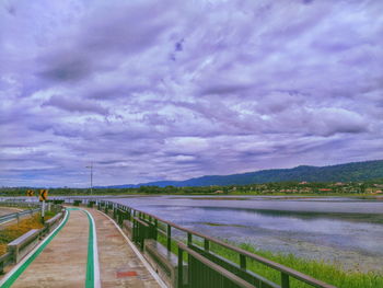 Empty road against cloudy sky