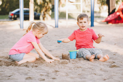 Siblings playing on sand