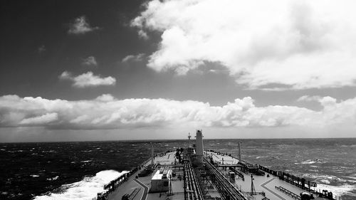 Cropped image of ship in sea against cloudy sky