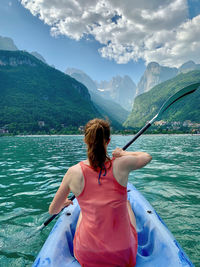 Rear view of woman walking on mountain against sky