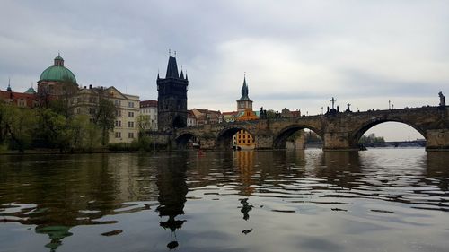 Arch bridge over river against buildings