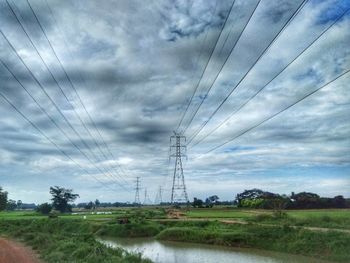 Electricity pylon on field against sky