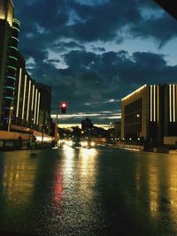 View of illuminated buildings against cloudy sky