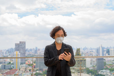 Portrait of man standing against cityscape