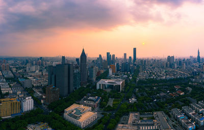 High angle view of modern buildings against sky during sunset