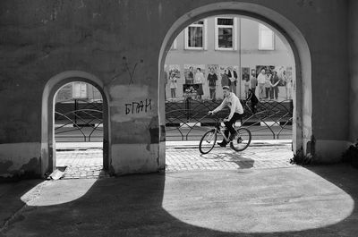 Rear view of man riding bicycle on street