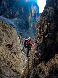 Side view of mature man climbing mountain