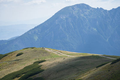 Hikers walking the ridge with big mountain in backdrop, slovakia, europe