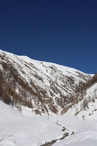 Snow covered mountains against clear blue sky