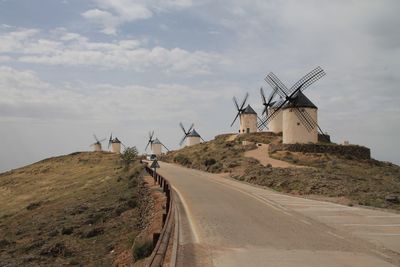 Traditional windmill on mountain against sky