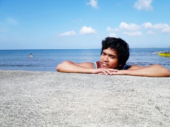 Young woman on beach against sky