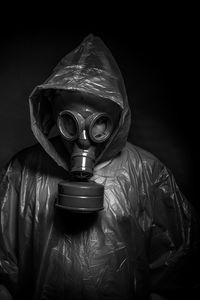 Man wearing gas mask against black background