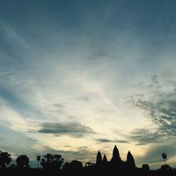 Silhouette of buildings against cloudy sky