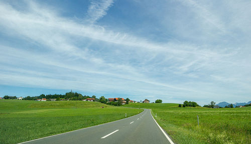 Empty road along countryside landscape