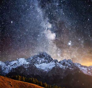 Scenic view of snowcapped mountains against sky at night