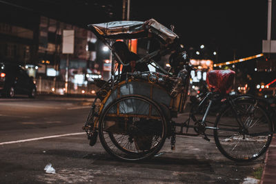 Bicycles parked on street in city at night