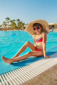 Portrait of young woman in bikini standing in swimming pool