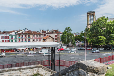 Cars on road by buildings against sky