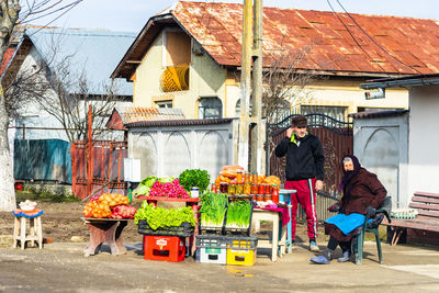 Group of people in market against building