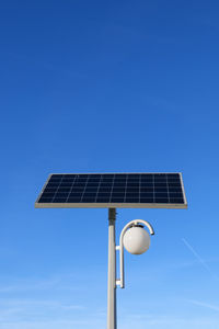 Low angle view of street light against blue sky