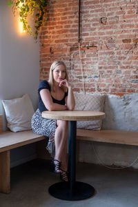 Young woman sitting on sofa at home