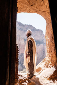 Rear view of man standing on rock