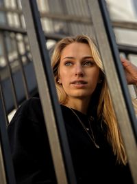 Portrait of young woman looking through window