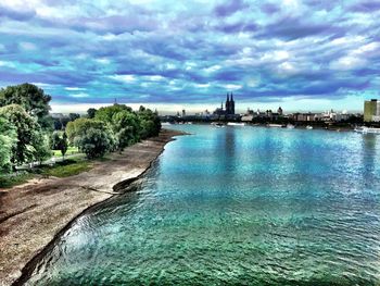 Scenic view of river against cloudy sky
