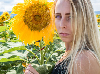 Portrait of woman with sunflower in garden