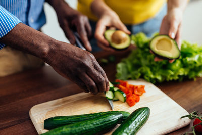 Midsection of man preparing food on cutting board